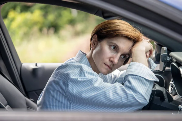 疲劳的中年妇女驾驶汽车 在道路上等待问题 在交通堵塞与方向盘上的头 紧张的女性感到疲劳站在高峰时间的路上 气馁的司机 — 图库照片