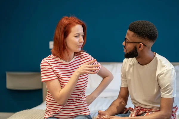 stock image Young interracial couple husband and wife sit on bed at home discussing intimacy issues, having disagreements and misunderstandings, speaking talking about relationship problems. Marital crisis