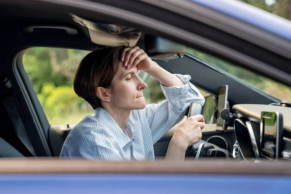 stock image Stressed middle aged woman driving car having problems on road looking ahead. Nervous female feeling fear, fright, aggression standing in traffic jam on rush hour. Exhausted frustrated shocked driver.