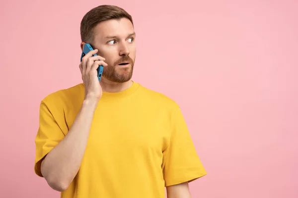 Удивительный Человек Отворачивается Разговаривая Мобильному Телефону Розовом Фоне Удивленный Парень — стоковое фото
