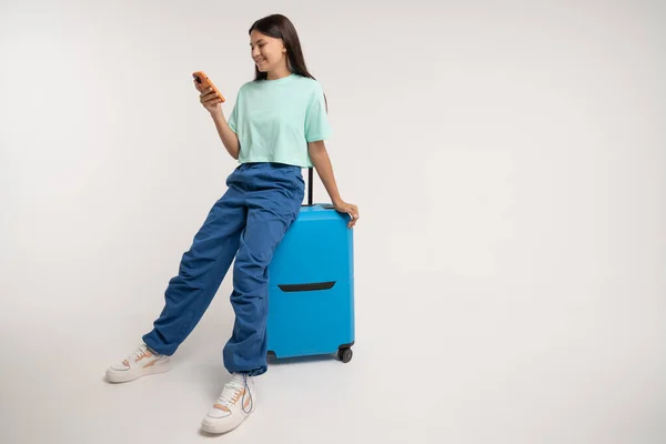 Glimlachend Tienermeisje Zit Reisblauwe Koffer Met Smartphone Happy Tiener Meisje — Stockfoto