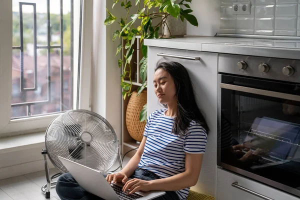 Relaxado Mulher Asiática Digitando Laptop Refrigeração Por Ventilador Elétrico Chão — Fotografia de Stock