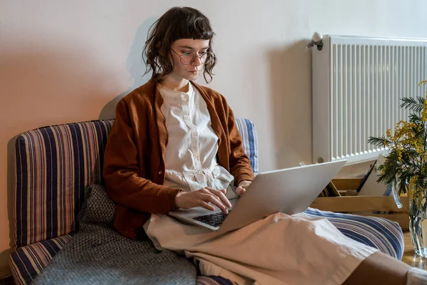 Chica Freelancer Enfocado Sentarse Sofá Con Ordenador Portátil Piernas Cruzadas —  Fotos de Stock
