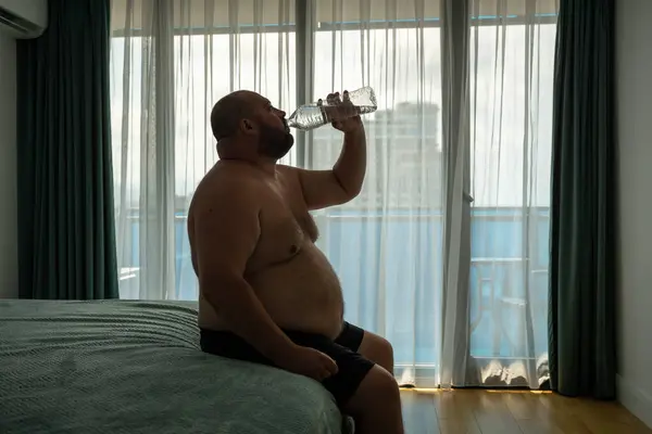 Extremely Fat Guy Drinks Lot Water Sits Bed Trying Cool — Stock Photo, Image