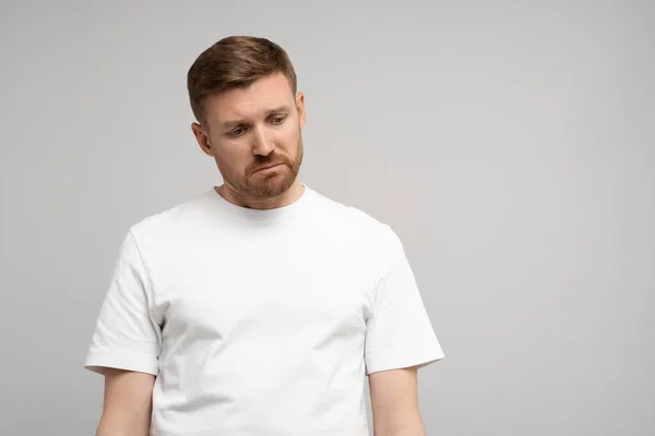 stock image Sad disappointed man with head down on gray background. Portrait of young upset frustrated guy. Problems, depression, desperation, hopelessness, frustration concept. Negative human sincere emotions.