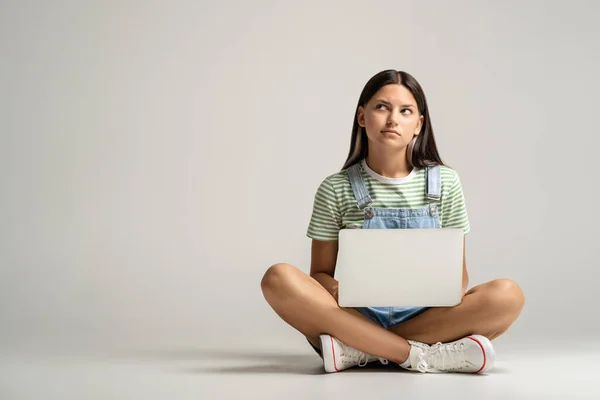 Teen Girl Sitzt Auf Grauem Hintergrund Und Hält Ein Kleines — Stockfoto