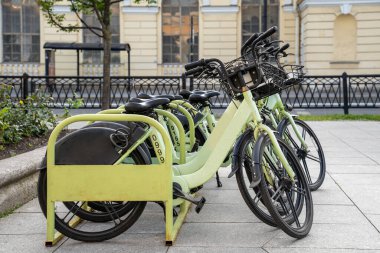 Parking area with cycles, bicycle sharing, healthy lifestyle, bicycle rental in city through mobile app. Public bike rack. Automated stations, free, very cheap access to ecologic transport. clipart