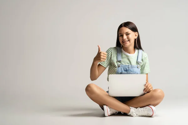 Teen Girl Laptop Hands Showing Thumb Sitting Gray Background Looking — Stock Photo, Image