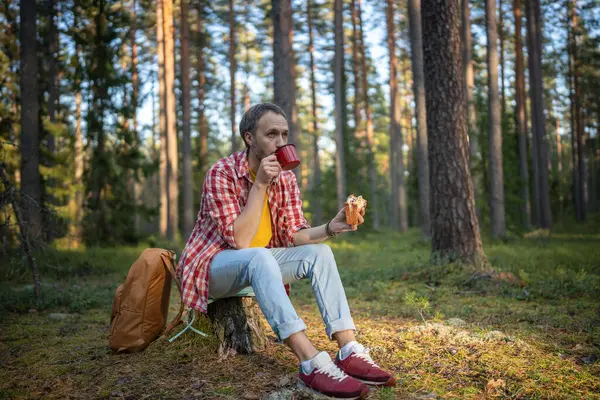 Kampçı Ormanda Çay Içip Sandviç Yiyor Kütüğün Üzerinde Oturarak Doğanın — Stok fotoğraf