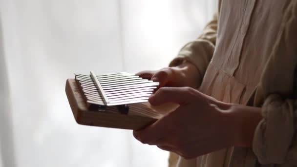 Γυναίκα Χέρια Παίζει Μουσική Kalimba Στέκεται Κοντά Στο Παράθυρο Στο — Αρχείο Βίντεο