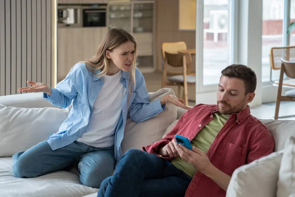 Focused Man Hang Out Smartphone Ignoring Unpleased Woman Sits Couch — Stock Photo, Image