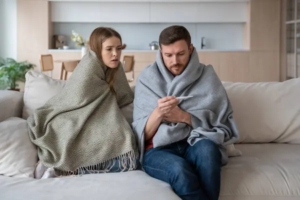 Sick Couple Sitting Sofa Wrapped Blanket Checking Temperature Thermometer Wife — Stock Photo, Image