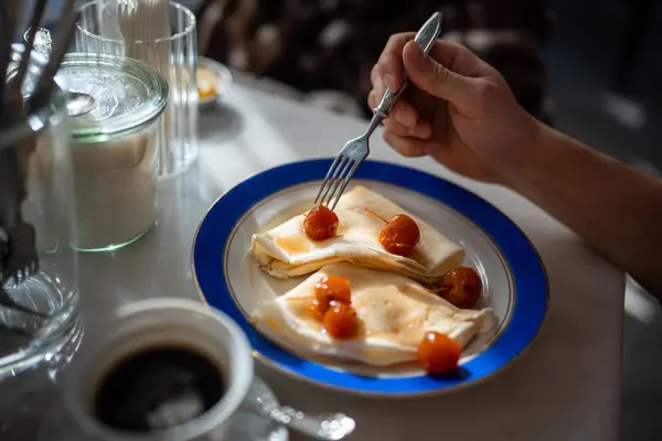 stock image Man having tasty breakfast in restaurant pancakes with jam from apples ranets. Delicious fresh food in cafe. Guy eating with fork. Gourmet, gastronomy, cuisine concept. Balanced healthy nutrition.