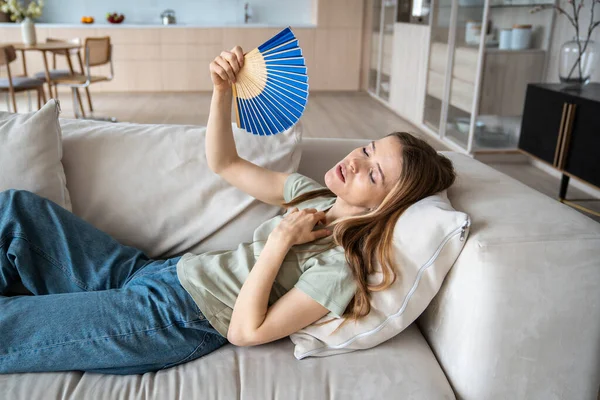 Unhappy Exhausted Overheated Young Woman Lying Sofa Home Waving Paper — Stock Photo, Image