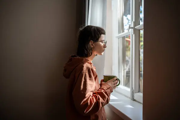 Samotna Smutna Kobieta Filiżanką Herbaty Wyglądająca Przez Okno Nietowarzyska Nastolatka — Zdjęcie stockowe