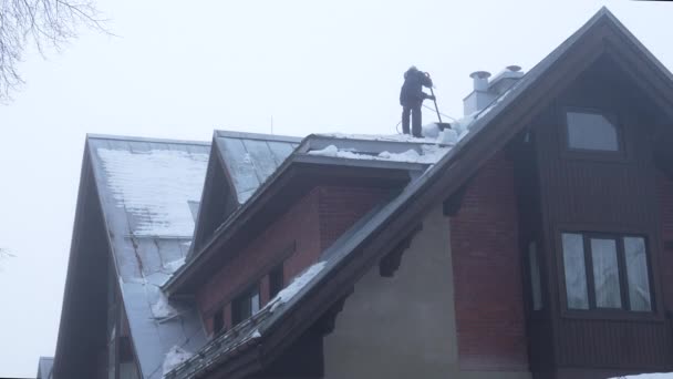 Pracownik Usuwający Śnieg Łopatą Dachu Serwis Czyszczenia Dachów Budynków Opadach — Wideo stockowe