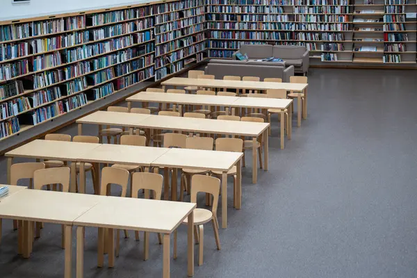 2024年2月11日 ロシア ヴィボルグ 木製のテーブルと椅子 本でいっぱいの本棚と棚が付いている学生図書館の内部 リラックスして読む場所 — ストック写真