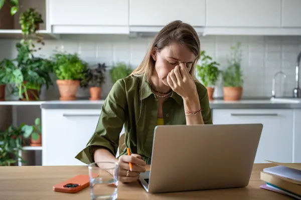 stock image Overworked female freelancer having headache, stress, fatigue, nervous overload of hard job, sitting at table with eyes closed, trying to relax. Tired woman unable to keep to deadline with urgent task