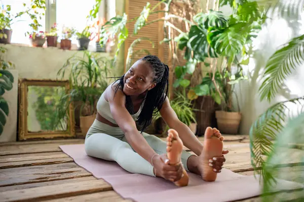 Tatmin Olmuş Afro Amerikalı Kadın Spor Salonundaki Bitkilerle Çevrili Yoga — Stok fotoğraf