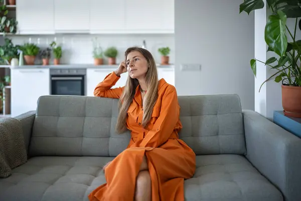 Relajada Mujer Pensativa Sentada Sofá Mirando Lado Soñando Despierto Casa —  Fotos de Stock