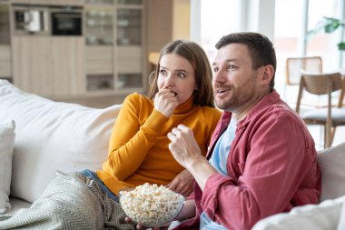 Şaşkın adam ve kadın birlikte TV filmi izliyorlar. Evde kanepede oturup patlamış mısır yiyorlar. Aile çiftinin kocası dizi bağımlısı olmuş. Hobi, eğlence, televizyon izlemek, dinlenme haftasonu..