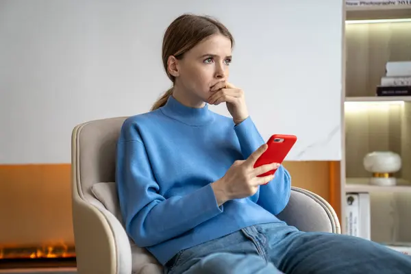 stock image Confused busy woman holding smartphone, thinking over work and financial tasks. Female with hand covering mouth, handling banking, online payments, digital commerce, solving financial problems