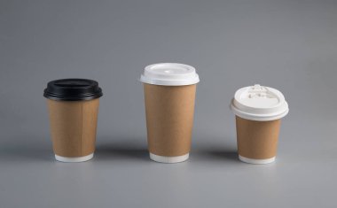 Masanın üzerinde kapağı olan karton bardak.