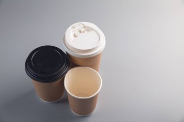 Masanın üzerinde kapağı olan karton bardak.