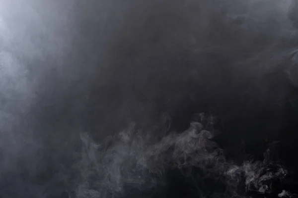 白い煙と黒い背景の霧の濃いふわふわのパフ 抽象的な煙雲 動きが焦点からぼんやりとした 空気中でなびくドライアイスフライから煙が吹く 効果的なテクスチャ — ストック写真
