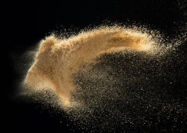 Kum patlaması, altın kum dalgası patlaması. Soyut kum bulutu sineği. Sarı renkli kum damlaları içine hava atıyor. Siyah arkaplan izole edilmiş yüksek hızlı deklanşör, dondurma hareketi atıyor