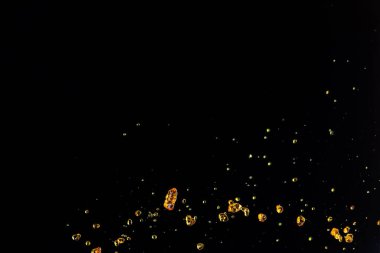 Portakal, limon suyu ya da yağ damlası, sıvı sarı içecek damlaları. Meyve suyu elementleri sıraya dizildi. Taze su sıçratma ve akan jetler, siyah arkaplan izole edilmiş dondurucu hareket