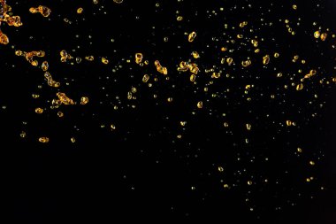 Portakal, limon suyu ya da yağ damlası, sıvı sarı içecek damlaları. Meyve suyu elementleri sıraya dizildi. Taze su sıçratma ve akan jetler, siyah arkaplan izole edilmiş dondurucu hareket