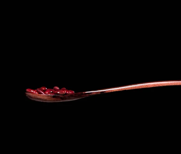 赤豆秋 赤粒豆抽象的な雲が爆発木製のスプーンから飛ぶ 美しい完全な種子エンドウ豆 食品オブジェクトのデザイン 選択的フォーカスフリーズショット黒の背景を隔離 — ストック写真