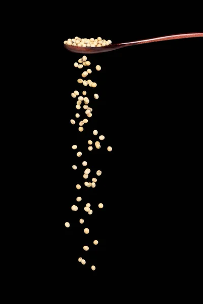 豆豆掉下来了 黄谷豆从木勺里喷出了抽象的云彩 美丽完整的豌豆种子 食物物体的设计 选择性聚焦冻结拍摄黑色背景隔离 — 图库照片