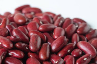 Kırmızı fasulye yığını, soyut bulut grubuna dökülen kırmızı tahıl taneleri. Güzel bir bezelye tohumu, yiyecek nesnesi tasarımı. Seçici odak dondurma görüntüsü beyaz arkaplan izole