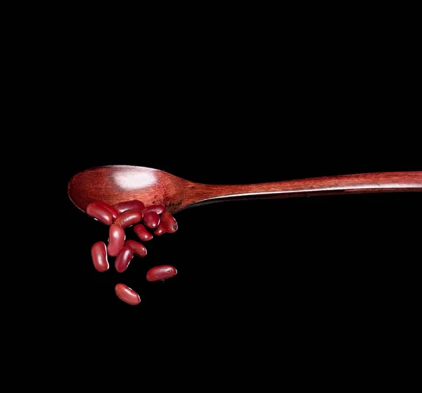 红豆掉落 红豆从木勺喷出抽象的云雾 美丽完整的豌豆种子 食物物体的设计 选择性聚焦冻结拍摄黑色背景隔离 — 图库照片