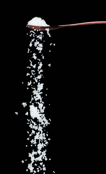 盐掉下来了 晶莹的白粒花生从木勺里喷出抽象的云彩 美丽完整的种子盐 食物物体的设计 选择性聚焦冻结拍摄黑色背景隔离 — 图库照片