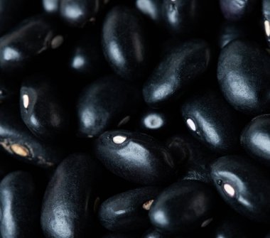 Makro, siyah fasulye dokusu, yuvarlak fasulye. Güzel bir bezelye tohumu, yiyecek nesnesi tasarımı. Seçici odak dondurucu çekim siyah arkaplan izole