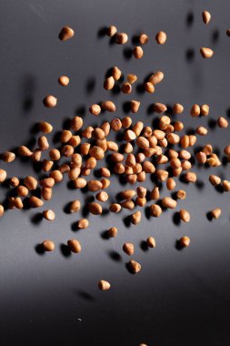 Yer fıstığı patlaması, kahverengi tahıl fıstığı soyut bulut sineği patlaması. Fıstık ezmesi havada uçuşur, yiyecek nesnesi tasarlanır. Seçici odak dondurucu çekim siyah arkaplan izole