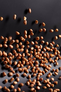 Yer fıstığı patlaması, kahverengi tahıl fıstığı soyut bulut sineği patlaması. Fıstık ezmesi havada uçuşur, yiyecek nesnesi tasarlanır. Seçici odak dondurucu çekim siyah arkaplan izole