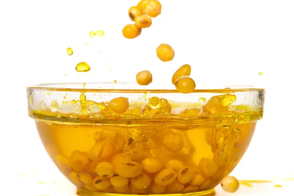 Yellow Soy Bean in Vegetable Oil pour fall down in Air. Golden Soybean mix with cooking oil pouring into bowl, soy bean is healthy diet and food element cooking ingredients. White background isolated