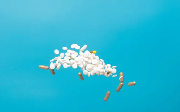 Daily pill drug medicine falling down float to patient. Many kind of drugs pills medicines to help patient fly to senior. Mixed combination Drug pill medicine Medical over blue background isolated