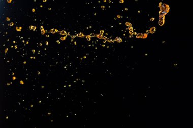 Portakal, limon suyu ya da yağ damlası, sıvı sarı içecek damlaları. Meyve suyu elementleri sıraya dizildi. Taze su sıçratma ve akan jetler, siyah arkaplan izole edilmiş dondurucu hareket