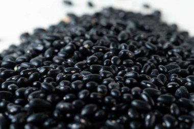 Kara fasulye yığını, soyut bulut grubundan aşağı dökülen kara tahıl taneleri. Güzel bir bezelye tohumu, yiyecek nesnesi tasarımı. Seçici odak dondurma görüntüsü beyaz arkaplan izole