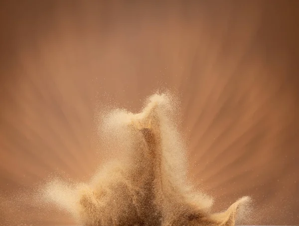 Small Fine size Sand flying explosion, Golden grain wave explode, abstract cloud fly. Yellow colored sand splash throwing in Air. Aura wallpaper background high speed shutter, freeze stop motion