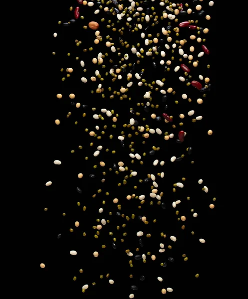 豆子跌落爆裂 几种豆子浮出爆裂 干枯的 混合的 黑的花生豆飞溅在空气中 黑色背景被隔离 — 图库照片