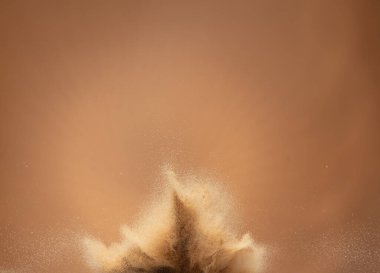 Small Fine size Sand flying explosion, Golden grain wave explode, abstract cloud fly. Yellow colored sand splash throwing in Air. Aura wallpaper background high speed shutter, freeze stop motion
