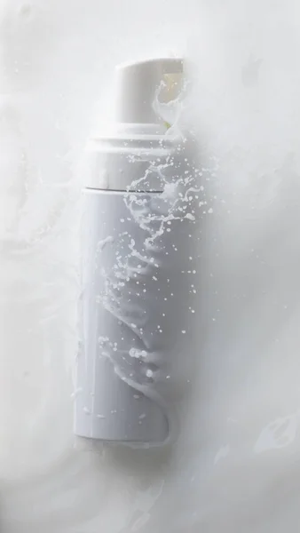 化粧品容器白い化粧水液滴が飛び散る 乳液を化粧品ボトルに流し込みます 保湿剤ローション爆発液 白の背景隔離された高速シャッターフリーズトップビュー — ストック写真