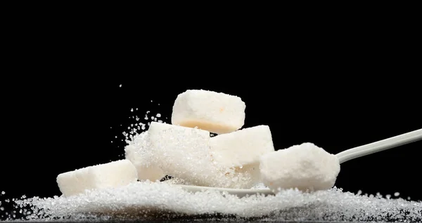 Pure Refined Sugar cube flying explosion, white crystal sugar abstract cloud fly. Pure refined sugar cubes splash stop in air, food object design. Black background isolated selective focus blur