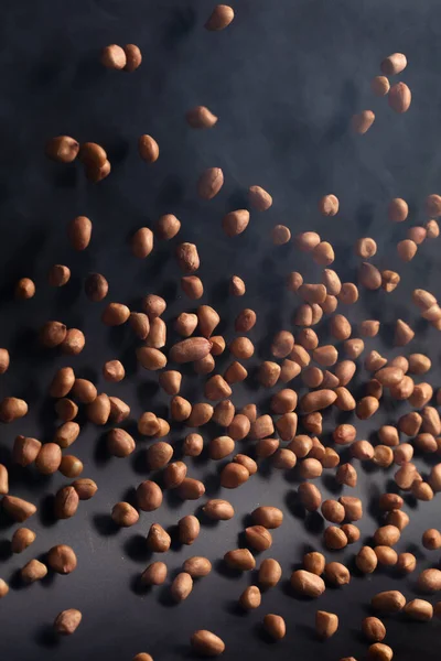 ピーナッツ飛んで爆発 茶色の穀物ピーナッツ抽象的な雲が爆発飛ぶ 空気中の美しい完全な種子エンドウ豆ピーナッツスプラッシュ 食品オブジェクトのデザイン 選択的フォーカスフリーズショット黒の背景を隔離 — ストック写真